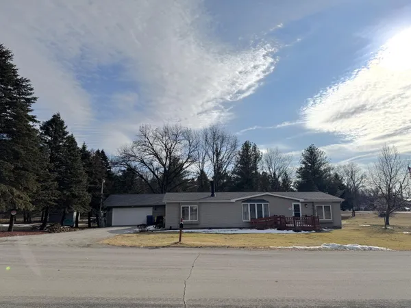 a view of house with yard and trees in the background