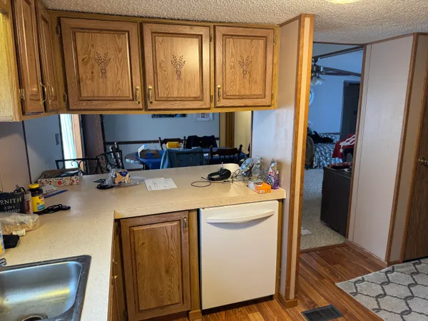 a kitchen with stainless steel appliances granite countertop a sink a stove and a refrigerator with wooden cabinets