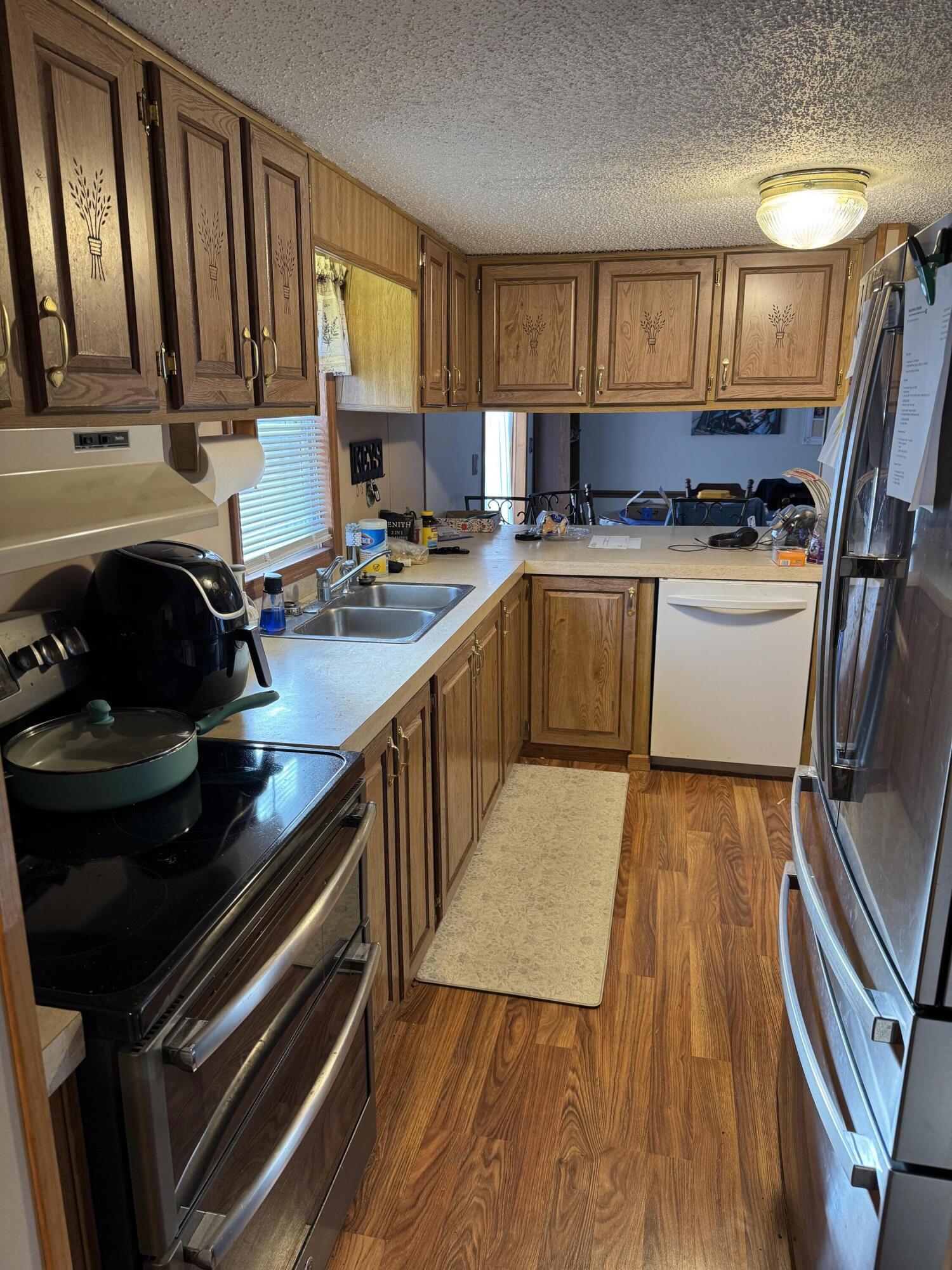25 East Carter Street Wheatfield, IN 46392 - Photo 10 of 22 a kitchen with a sink a stove cabinets and a wooden floor