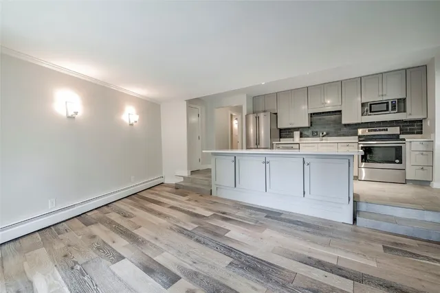 a view of kitchen with wooden floor and electronic appliances