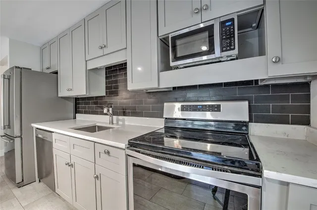a kitchen with stainless steel appliances granite countertop a stove microwave and refrigerator