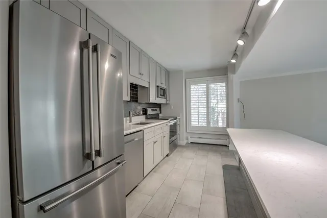 a kitchen with a refrigerator a sink and cabinets