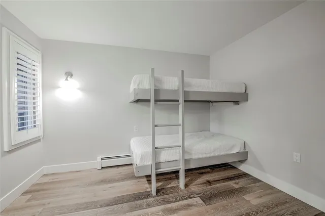 a bedroom with a bunk bed and a window