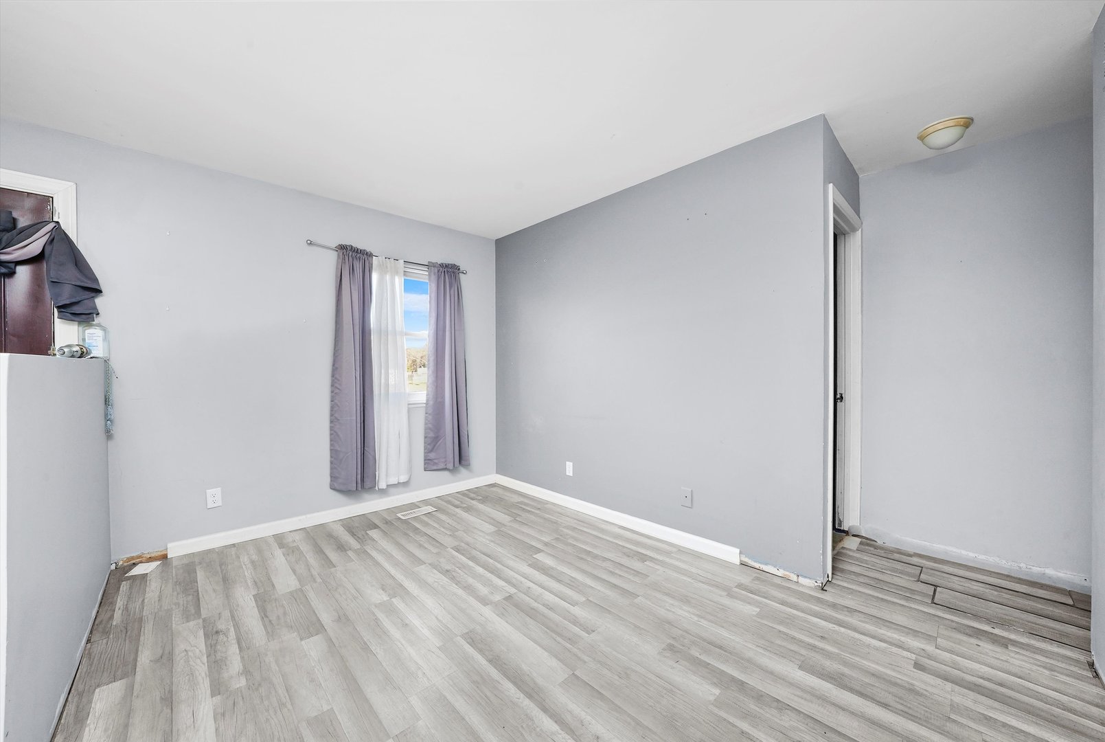 233 Rockhurst Road Bolingbrook, IL 60440 - Photo 10 of 29 a view of an empty room with wooden floor and a window