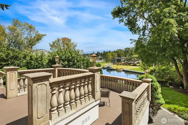 a view of a roof deck with couches and wooden fence