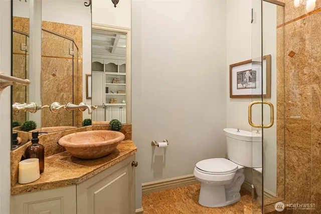 a bathroom with a granite countertop toilet sink and mirror