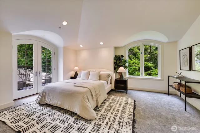 a bedroom with a bed and a large window