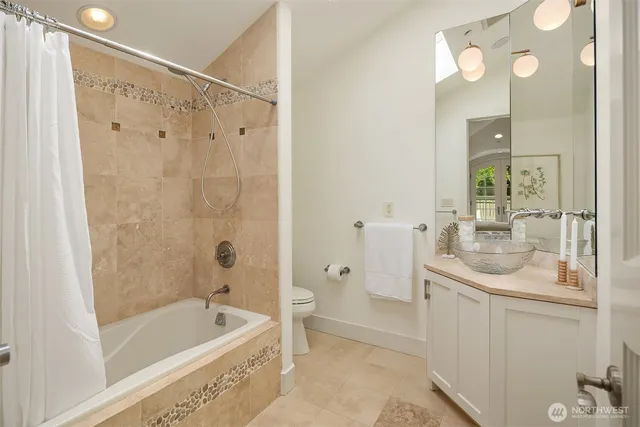 a bathroom with a granite countertop sink a mirror a bathtub and shower