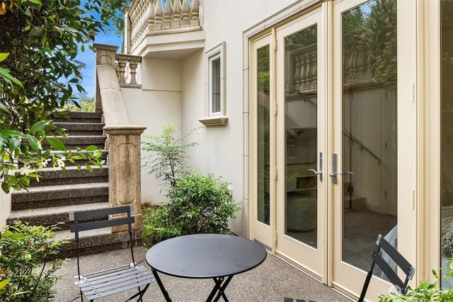 a view of a balcony with chairs and potted plants