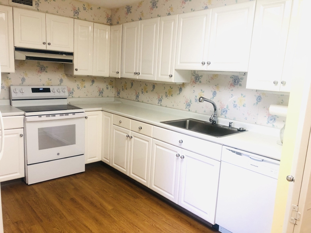 402 Paradise Road, Unit 2L Swampscott, MA 01907 - Photo 8 of 11 a kitchen with granite countertop white cabinets and white appliances