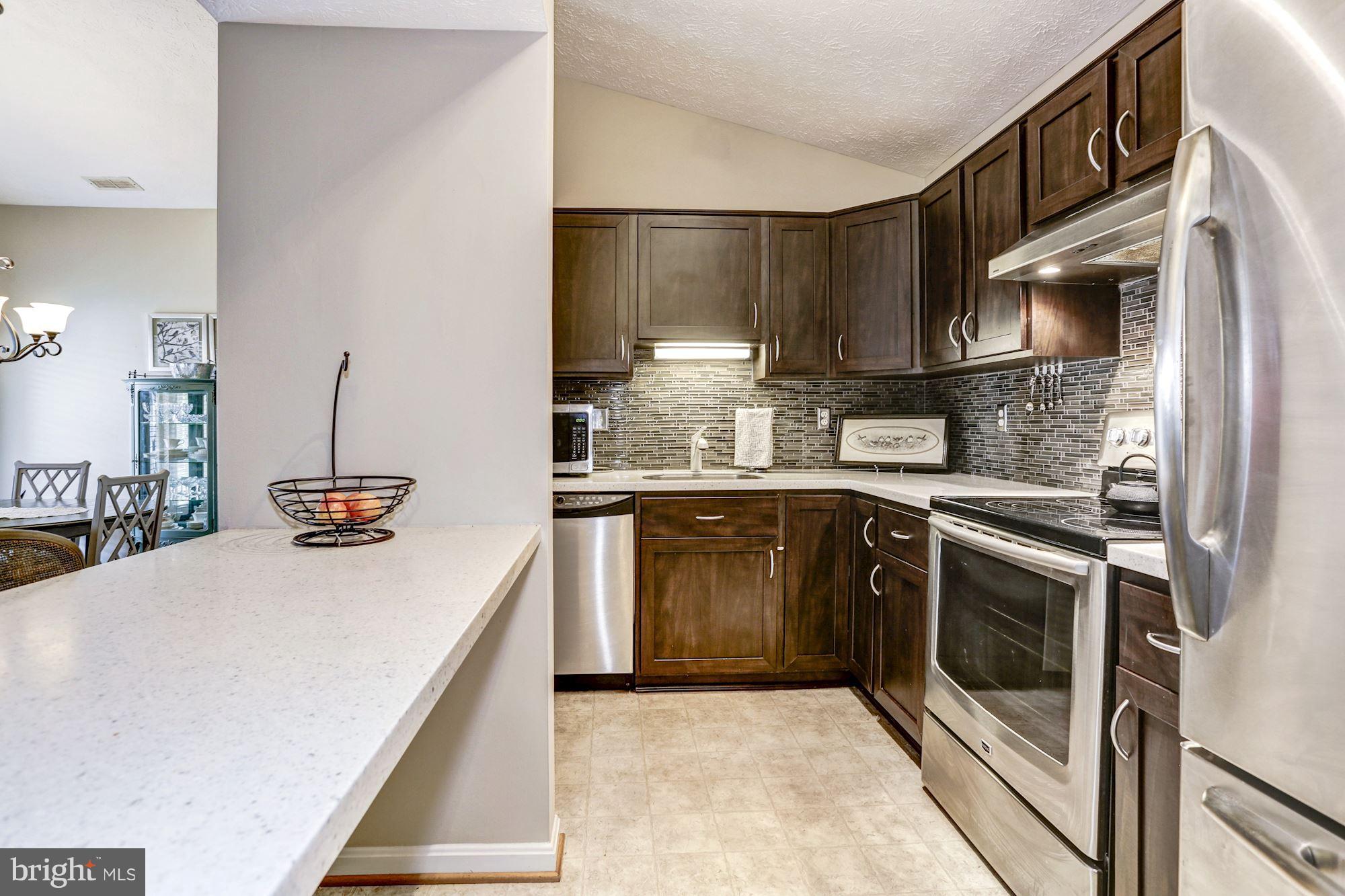 2102 Whitehall Road, Unit 2C Frederick, MD 21702 - Photo 11 of 28 a kitchen with stainless steel appliances granite countertop a sink a stove and a wooden floors