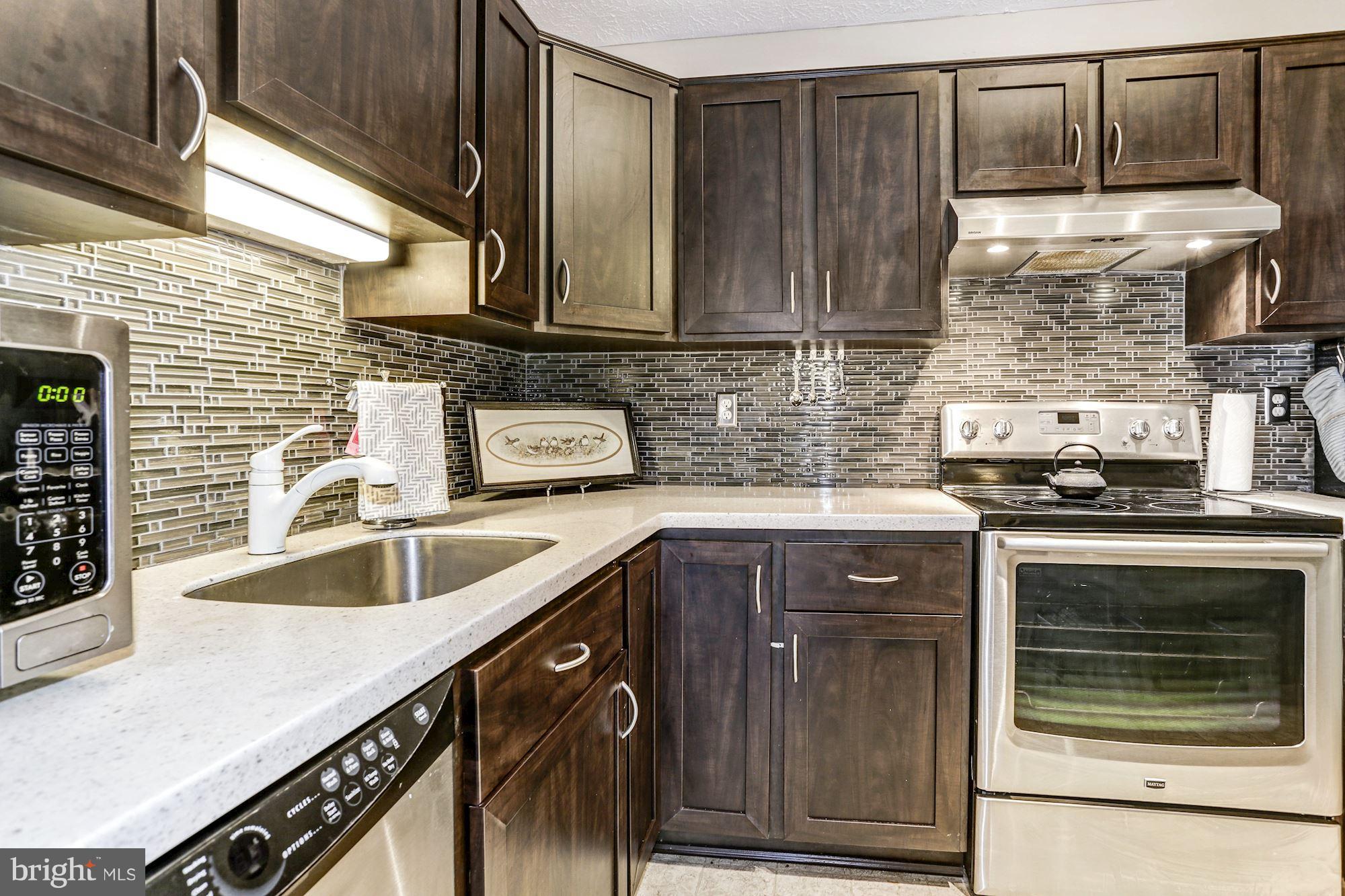 2102 Whitehall Road, Unit 2C Frederick, MD 21702 - Photo 12 of 28 a kitchen with granite countertop stainless steel appliances wooden cabinets sink and stove