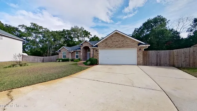 a front view of house with yard and trees all around
