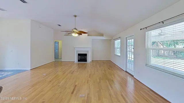 a view of empty room with wooden floor and fireplace