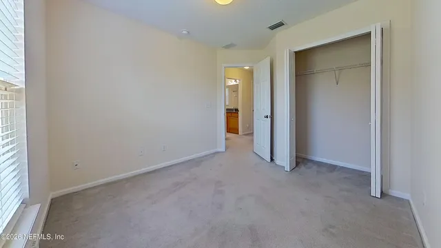 an empty room with closet and a window