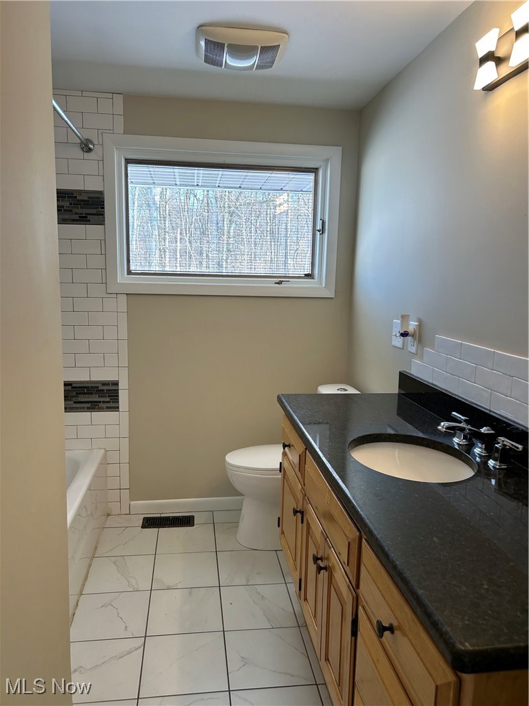 412 Barnard Road Wooster, OH 44691 - Photo 14 of 25 Full bathroom featuring vanity, new toilet, and tiled shower / bath