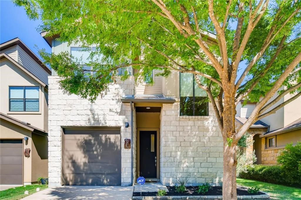 a front view of a house with a tree