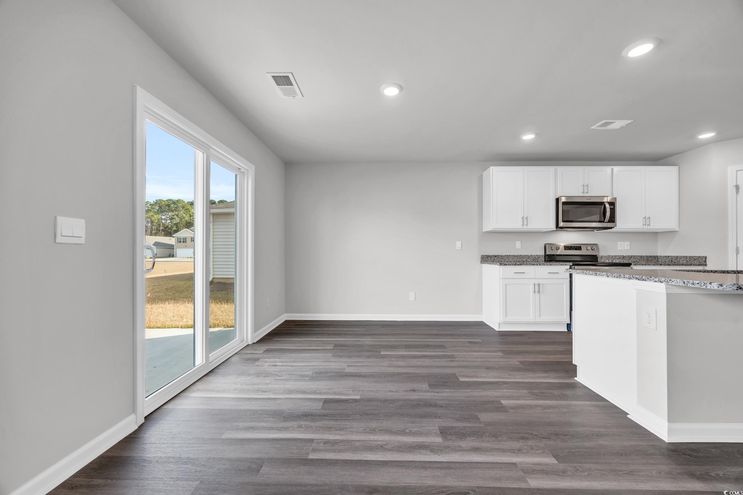 4071 Nelson Road Little River, SC 29566 - Photo 12 of 40 Kitchen featuring white cabinets, dark wood-type f