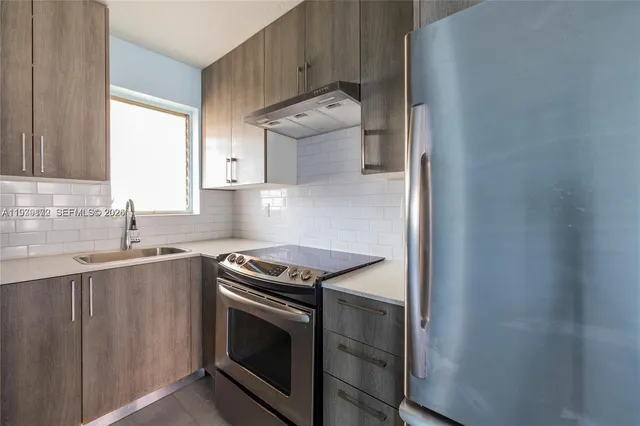 a kitchen with granite countertop a sink stove and cabinets