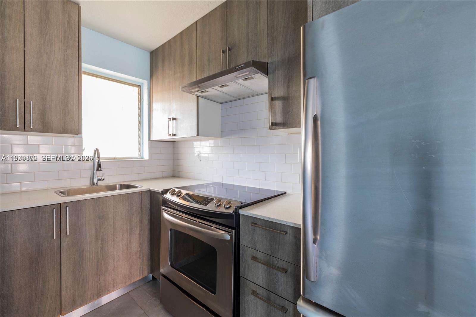a kitchen with granite countertop a sink stove and cabinets
