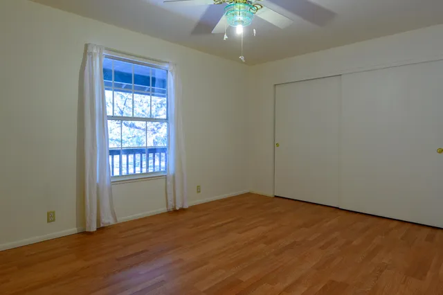 an empty room with wooden floor and windows