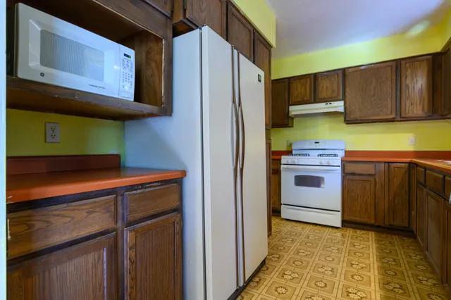 a kitchen with stainless steel appliances granite countertop a refrigerator and a stove top oven