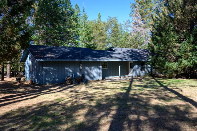 a view of a wooden house with a small yard