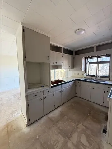 a view of a hallway with wooden floor and a bathroom