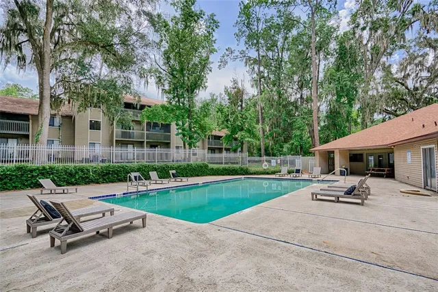 a view of a swimming pool with chairs and garden