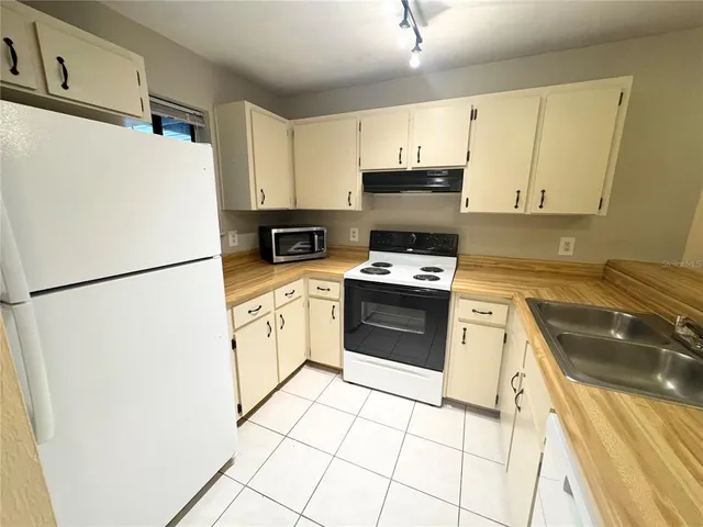 a kitchen with cabinets a refrigerator and a stove
