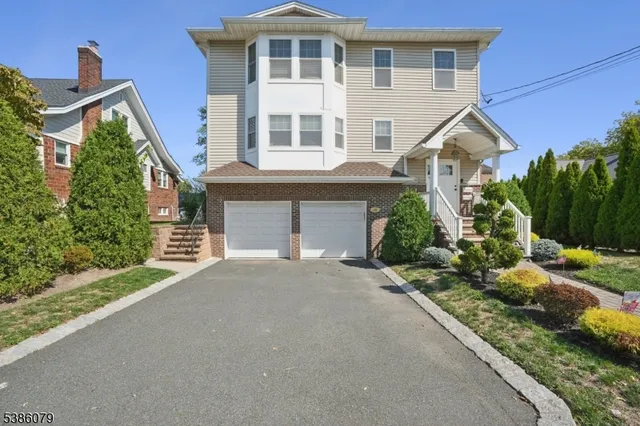 a front view of a house with a yard and potted plants