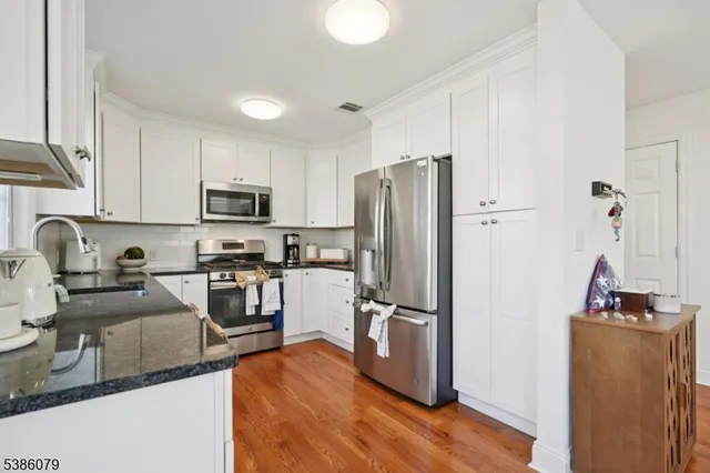 a kitchen with stainless steel appliances granite countertop a refrigerator stove microwave and sink