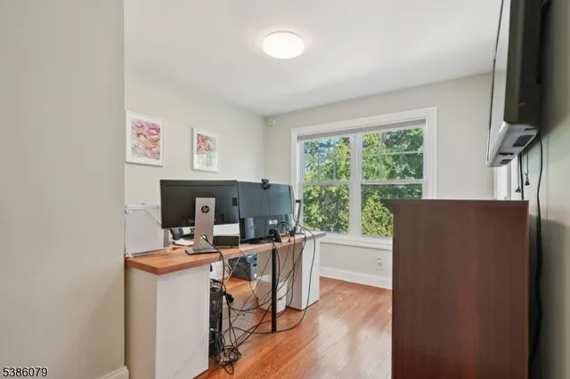 a view of a workspace with furniture and a window