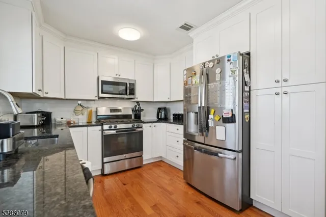 a kitchen with granite countertop a refrigerator stove and microwave