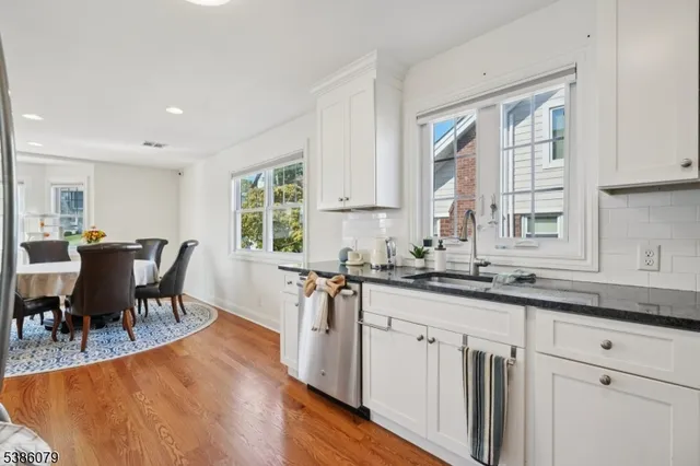 a kitchen with stainless steel appliances granite countertop a stove a sink a dining table and chairs