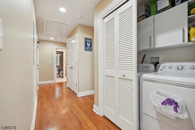a view of a hallway with entryway and wooden floor