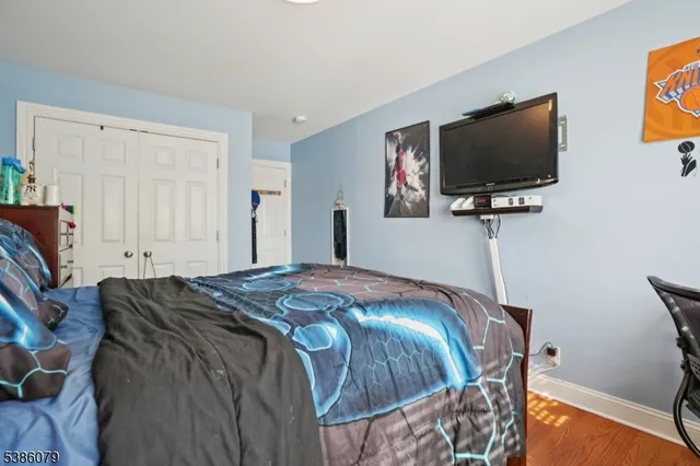 a bedroom with bed and a flat screen tv