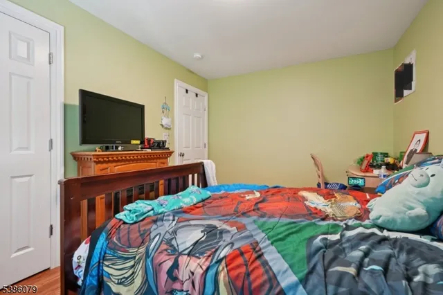 a bedroom with a bed and flat screen tv