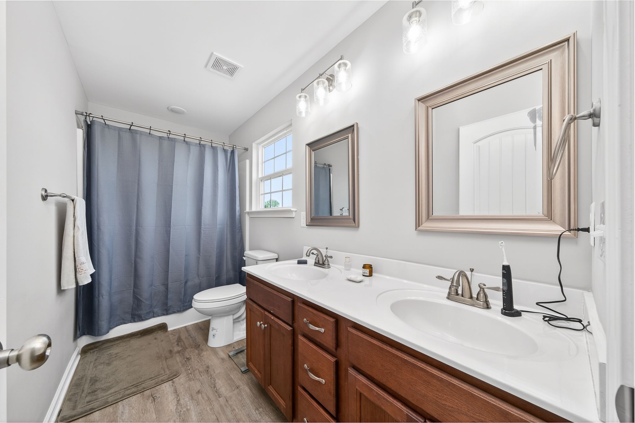 144 Liberty Road Sparta, TN 38583 - Photo 9 of 24 a bathroom with a double vanity sink a toilet and a mirror