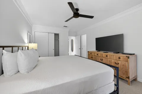 a bedroom with a bed and a flat tv screen on dresser