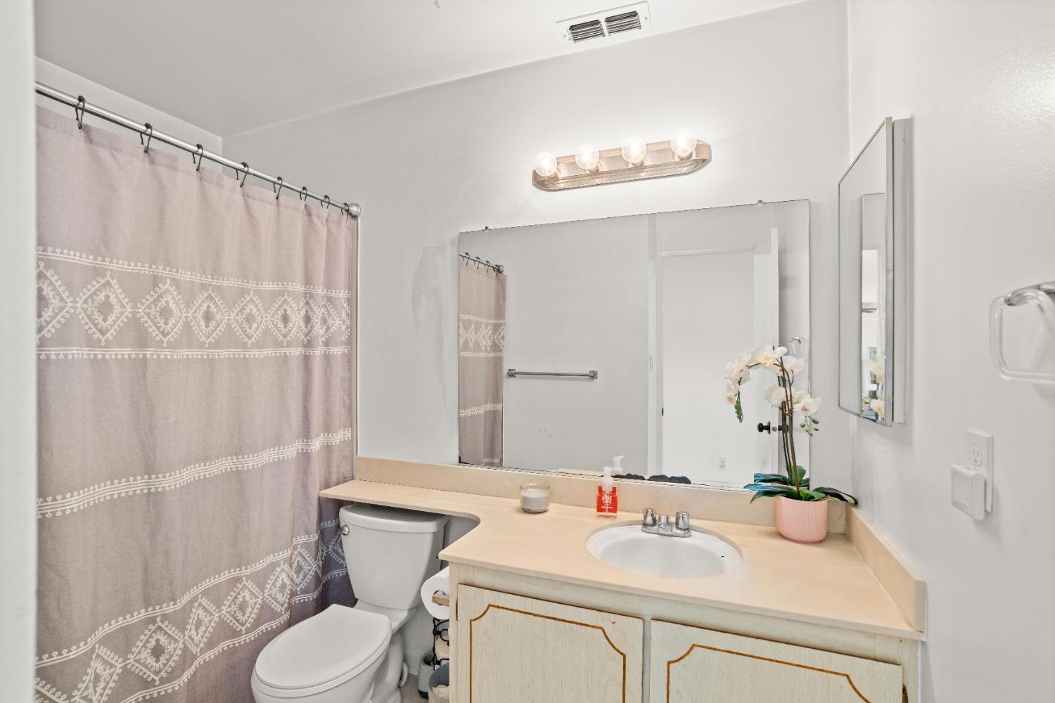 3412 Huntsman Drive Sacramento, CA 95826 - Photo 24 of 32 a bathroom with a sink a toilet and shower curtain