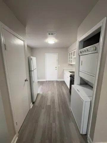a view of empty room with wooden floor and washer