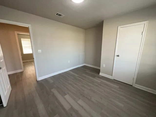 an empty room with wooden floor and entrance