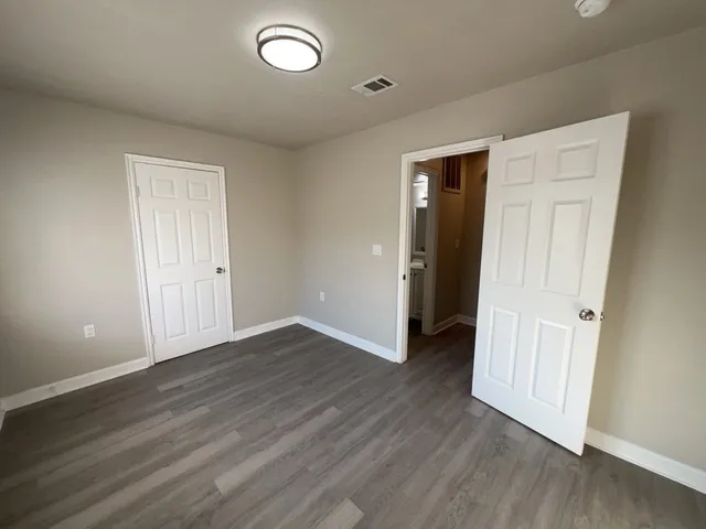 an empty room with wooden floor and closet