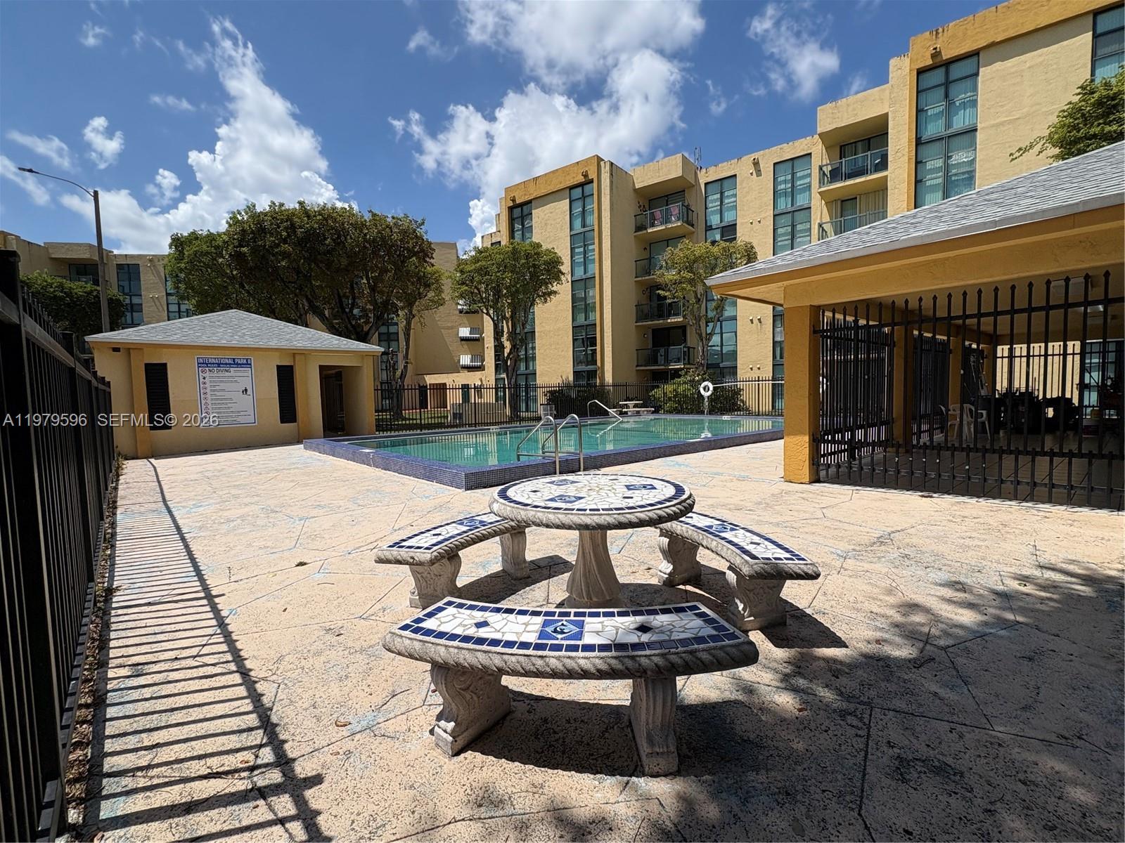 11800 Southwest 18th Street, Unit 5174 Miami, FL 33175 - Photo 20 of 22 a view of a patio with table and chairs with wooden floor and fence