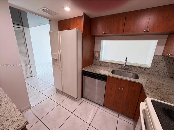 a kitchen with granite countertop a stove microwave and sink
