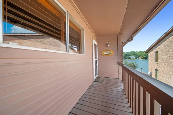 a view of a balcony with wooden floor and fence