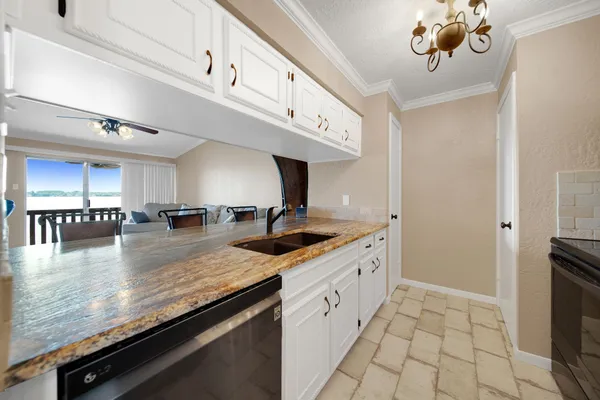 a kitchen with stainless steel appliances granite countertop a sink a stove and a refrigerator