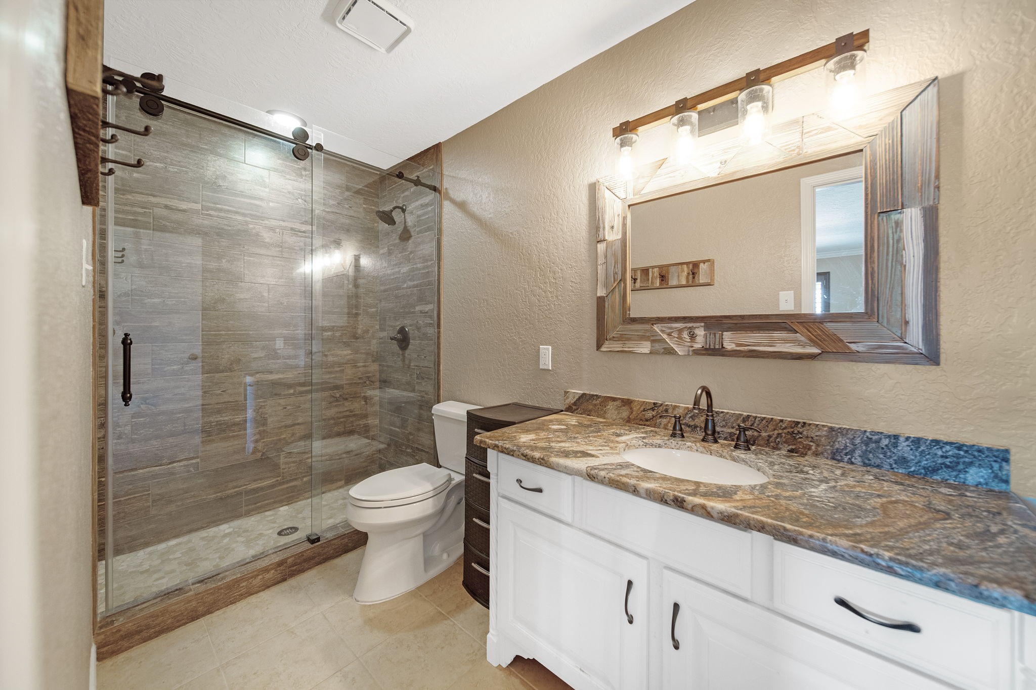 801 River Road, Unit E 116 Montgomery, TX 77356 - Photo 9 of 14 a bathroom with a granite countertop sink toilet and shower