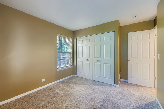 a view of an empty room with window and closet area